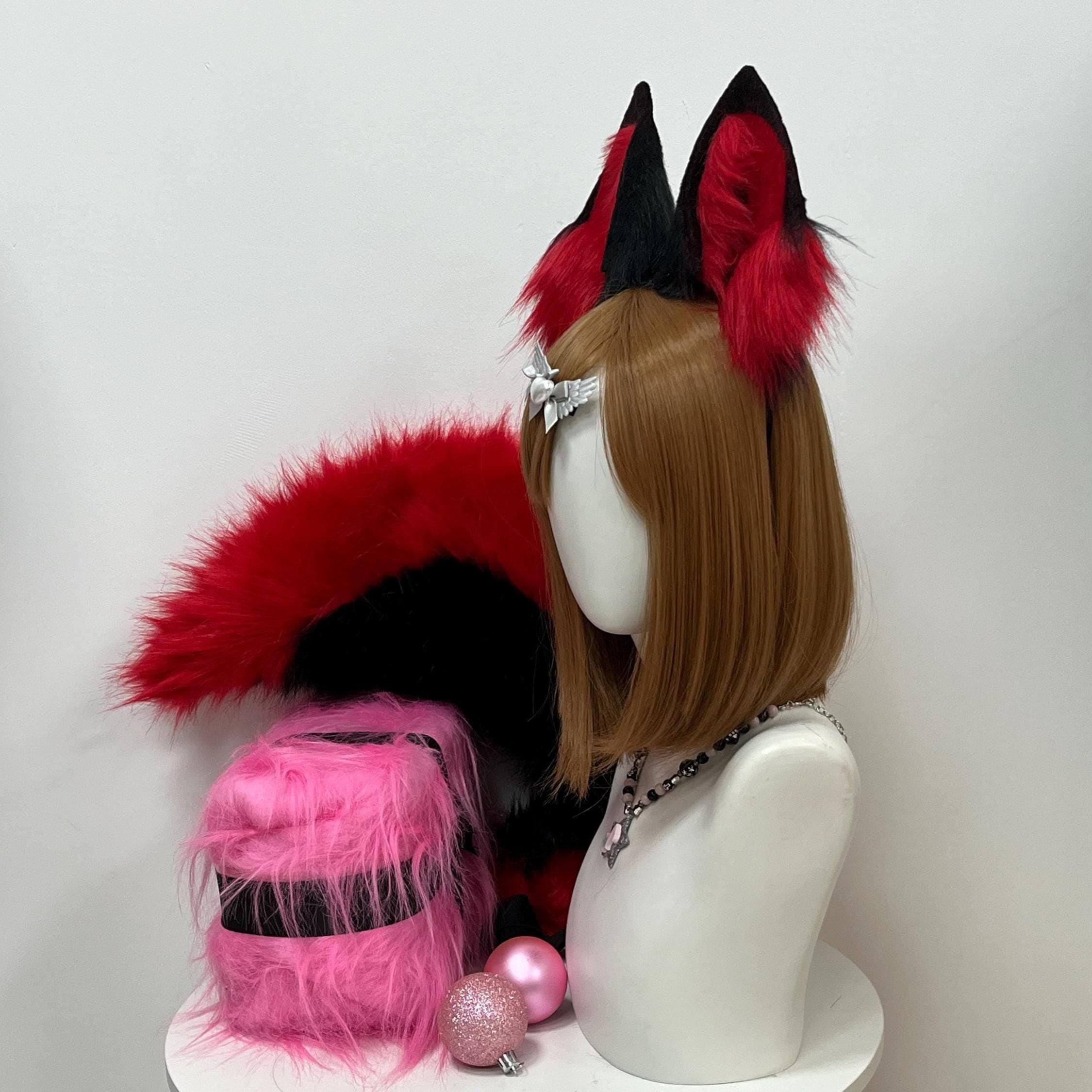 Side angle view black red fox ears and tail set highlighting how the handmade ears sit at a natural slightly forward angle while the long bushy fluffy fox tail hangs at the side showing its full length and tapered curly shape. The warm red fur catches studio lighting dramatically. Great profile reference for buyers who want to see the real scale of the tail against the ears the overall kit proportion and how dense the plush pile sits when photographed at an angled three quarter viewpoint.