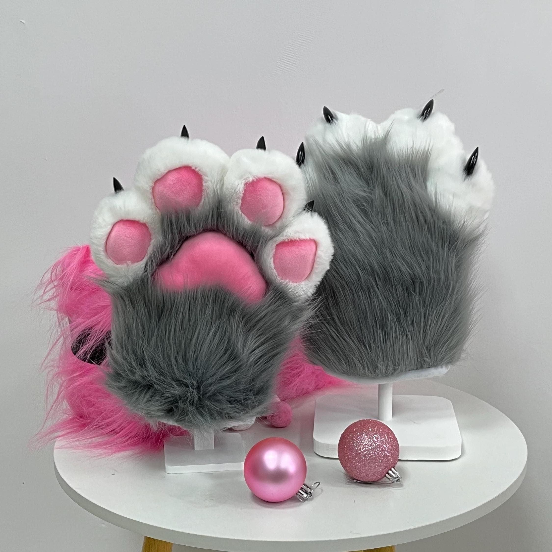 Grey toony handpaws back angle revealing the shaggy wolf fur topside, curved dark claws and fluffy white accent cuff fading into soft silver grey pile. Shows off the sculpted paw backs perfect for fursuiters building a husky, coyote, timber wolf or dire wolf character. Durable four finger mitten construction, polyester stuffed beans, minky fleece pads. Ready for furry fandom meetups, con photoshoots, cosplay skits, LARP battles and spooky Halloween monster costume builds.