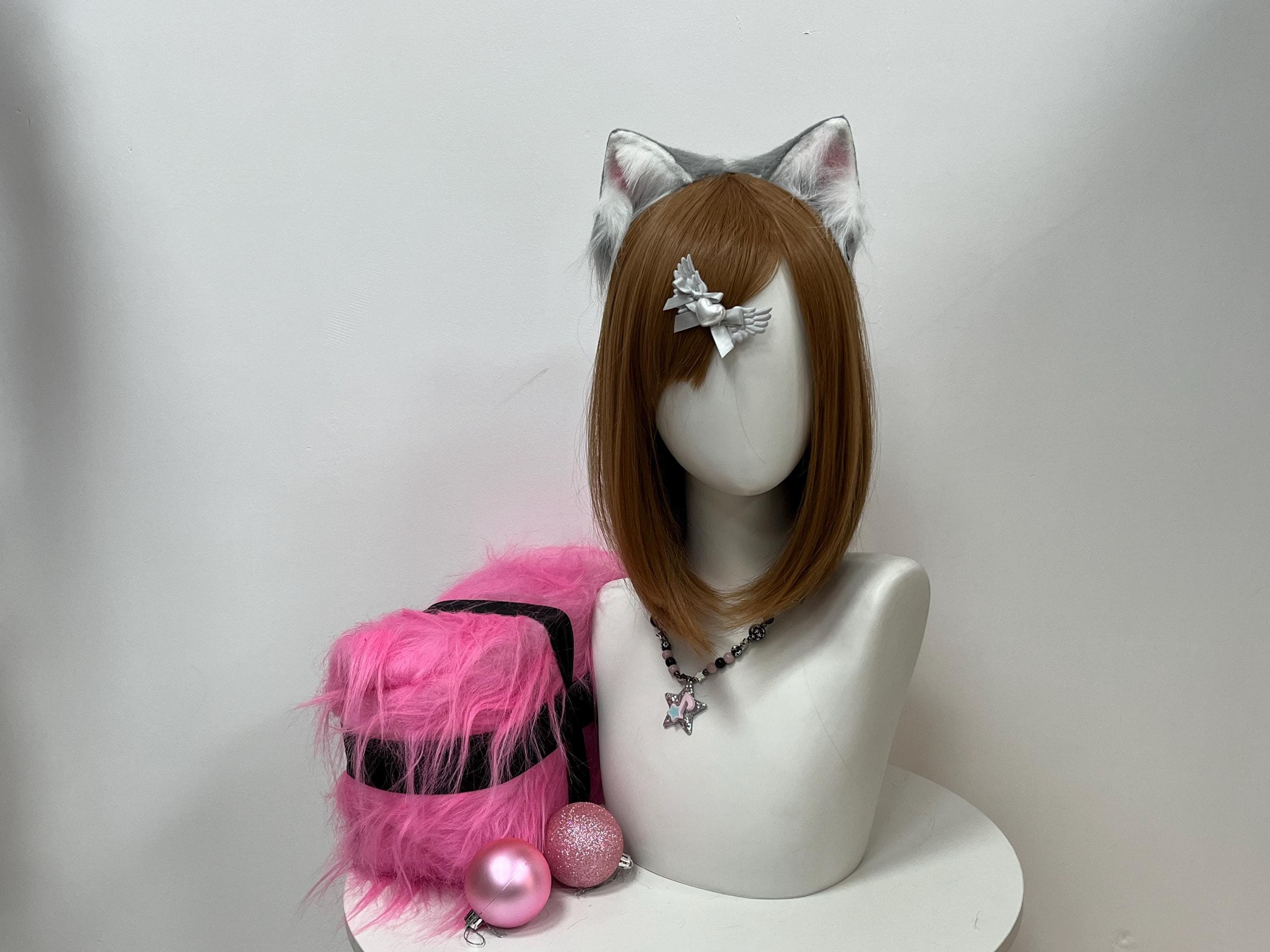 Front view of a handmade grey cat ears headband set on a neutral mannequin, spotlighting silver-grey outer faux fur, a creamy white fluff halo framing the ear base, and rose pink inner pads glowing warm under cool studio light. The curved kitten silhouette delivers pure gothic kawaii energy, locked in for therian kin sculpting a fursona, anime con panel-line photos, or late-night Halloween meetups where edgy fantasy flair steals the whole spotlight fast.