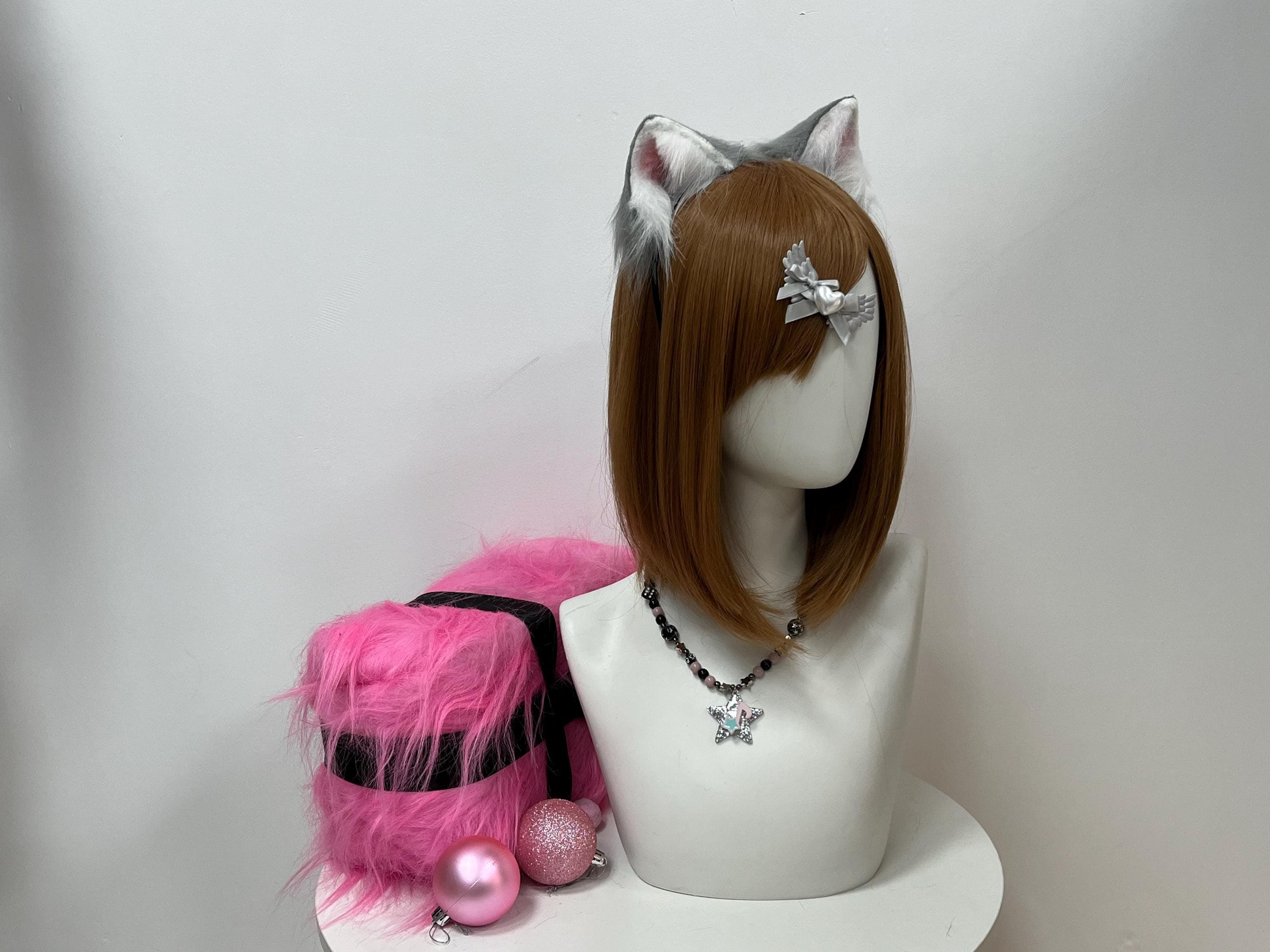 Straight-on front angle of the same grey kitten ears perched on a styling bust form, showing balanced twin ear tips, dense ash-grey pile blended with snowy ivory base tufts, and dusty rose inner panels popping cleanly against a soft cool studio wall backdrop. Pure yami-kawaii vibes built for therian expression, masquerade meetups, indie music festivals, fursona reveals, or cozy indoor cosplay shoots where cute-meets-creepy looks win every single photo frame.