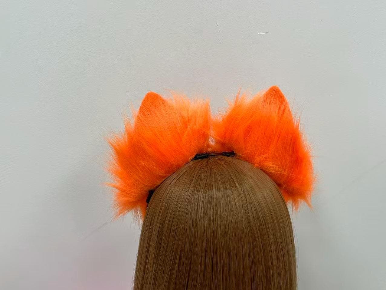 Looking from directly behind, the orange fox ears blend seamlessly into long flowing locks with full plush coverage and zero gap between ear bases. Neon tangerine fluff radiates outward in soft brushable strands, keeping the headband almost completely hidden. A go-to topper for kitsune dancers, autumn fursonas, hellhound builds, harvest festival looks, and any character ref calling for warm fiery animal headwear on stage or in dorm room photoshoots.