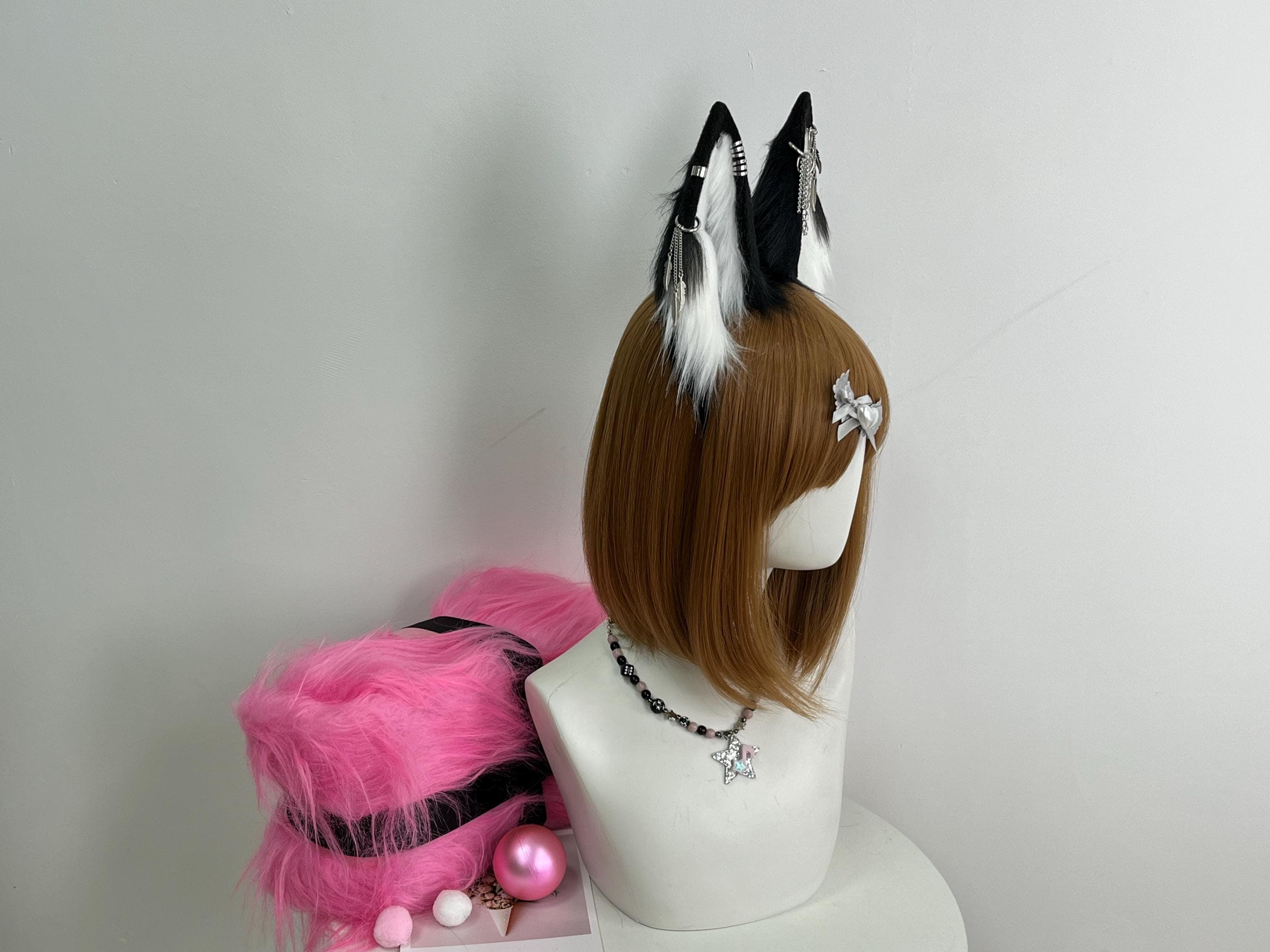 Back angled view of black white wolf ears headband revealing silver chain piercing placement on rear of ears with dangling feather charms visible behind the hair line for gothic therian punk wolf cosplay. Realistic faux fur wolf ear shape solid black outer white fluffy inner construction handmade for anime con kemonomimi character Halloween costume furry fandom rave festival alt fashion. Slim headband disappears into hair natural look all-day wear gift cosplayer.