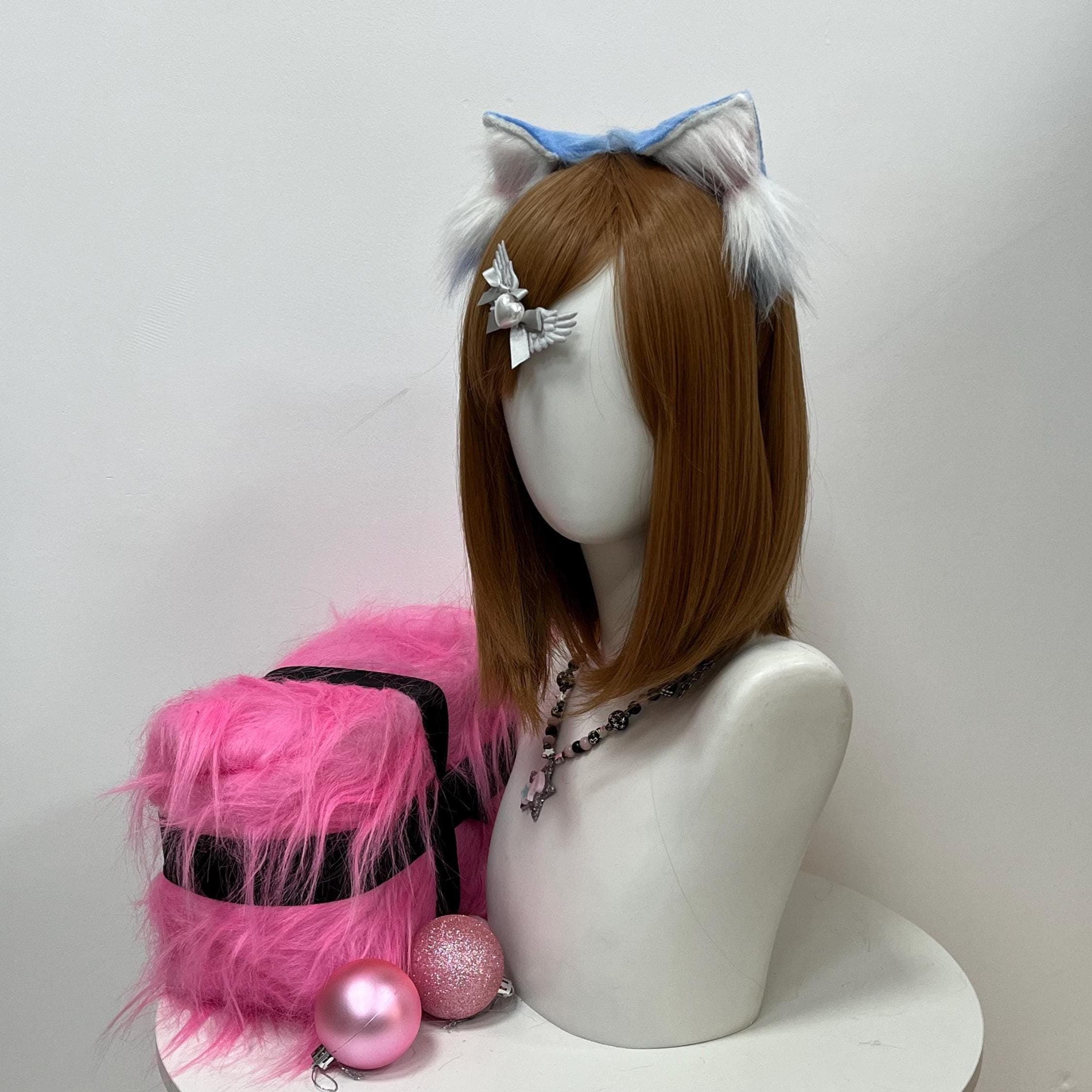 Three-quarter angle of the pale blue wolf ears headband highlighting the layered fur blend: glacial azure tipping sweeps over ivory cream core fluff dusted with subtle dusty-pink shading near the hidden base. The curved band sits flush against the scalp, the ears lean forward like an alert wild wolf tracking movement, and the faux fur pile stays lush through long wear — perfect for kemonomimi cosplayers, therian shifters, and bustling anime con halls.