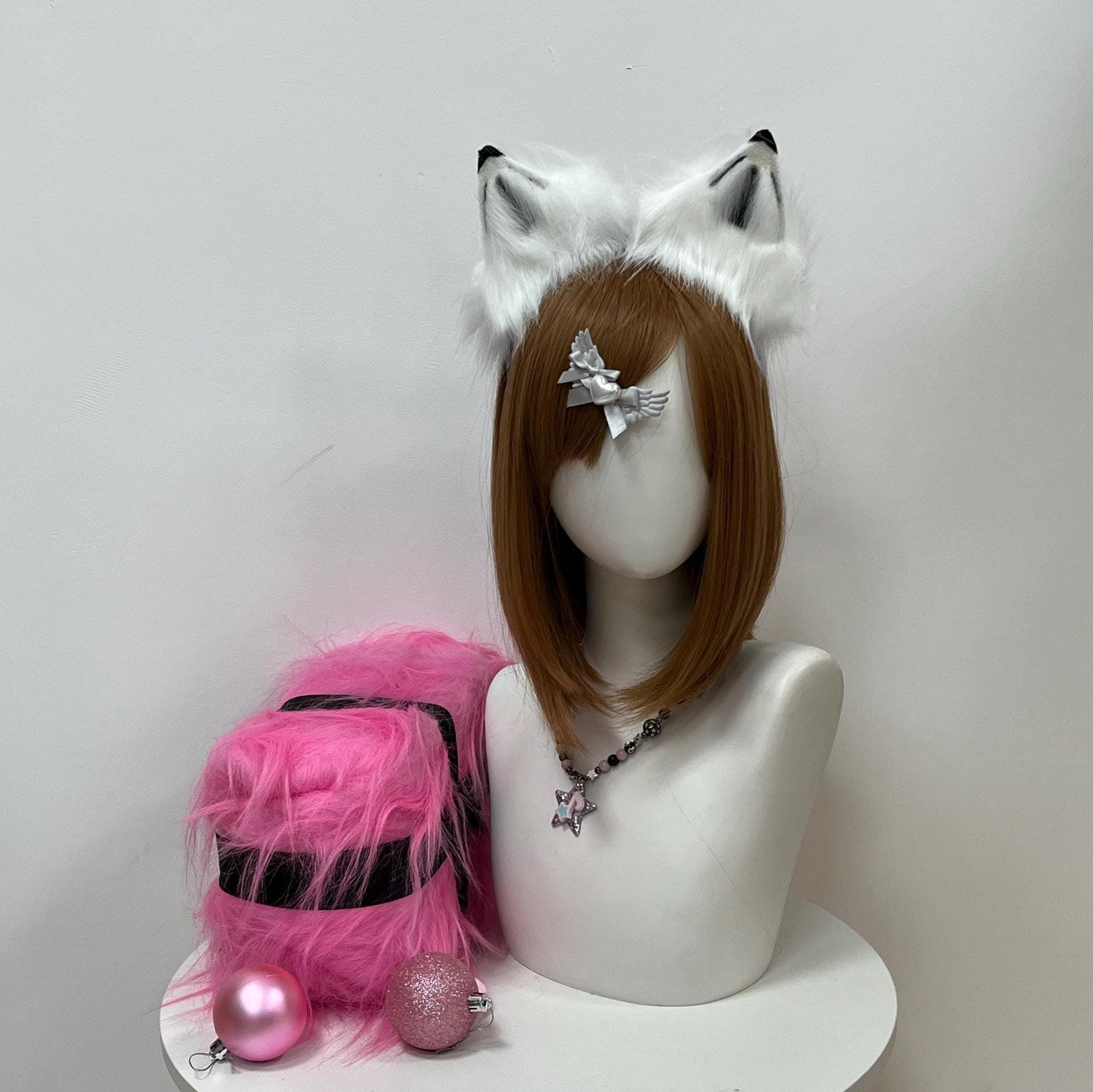 Realistic white and black wolf ears headband shown front-on, twin pointed ears crafted from snowy faux fur with charcoal-shaded inner channels and inky outer tips evoking a true timberwolf pelt. The handmade pair sits proud across the brow as a kemonomimi statement piece for furry conventions, anime club meetups, therian gatherings, or moody Halloween costuming. Cosplayers can channel a wild wolf spirit through long con days with quiet confidence and effortless style.