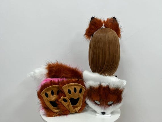 Embrace your inner cat with this full cosplay set including cat ears, paw gloves, mask, and tail. Designed from soft, high-quality faux fur, this set features a mix of brown and white fur that mimics the appearance of a real cat. Perfect for anime cosplay, furry fans, and Halloween. The adjustable headband ensures a comfortable fit, while the paws and tail complete the look.