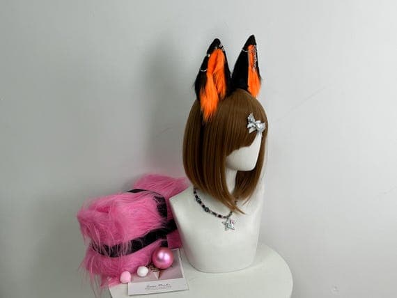 Wolf ears cosplay accessory in striking orange and black faux fur, handcrafted for costumes, Halloween looks, and furry character cosplay. These handmade ears sit securely on a headband, offering comfort and durability for events or photoshoots. A great gift for fans of handmade cosplay gear, realistic animal accessories, and custom costume design. Add these ears to your wolf costume or furry fashion outfit.