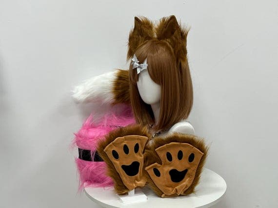 Fox cosplay set featuring soft, fluffy ears, paws, and tail made from high-quality faux fur. Realistic design with a white-tipped tail and curved, lifelike ears. Comfortable for extended wear, perfect for fursuits, petplay, and animal roleplay. Adjustable headband ensures the fox ears stay in place. Great for Halloween, cosplay conventions, or themed parties. Available in brown, red, or custom colors to suit your style.