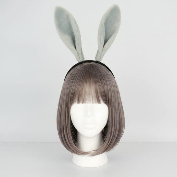 Soft plush bunny ears headband in neutral grey displayed on a mannequin head with styled wig. Faux fur rabbit ears standing 18cm tall on a cushioned padded black headband designed for comfortable extended wear. Lightweight 49g bunny costume accessory great for Halloween dress-up, Easter celebrations, cosplay events, anime conventions, themed photo shoots, and festival party outfits. Available in five versatile colors including pink, camel, black, and white plush rabbit ear headband options