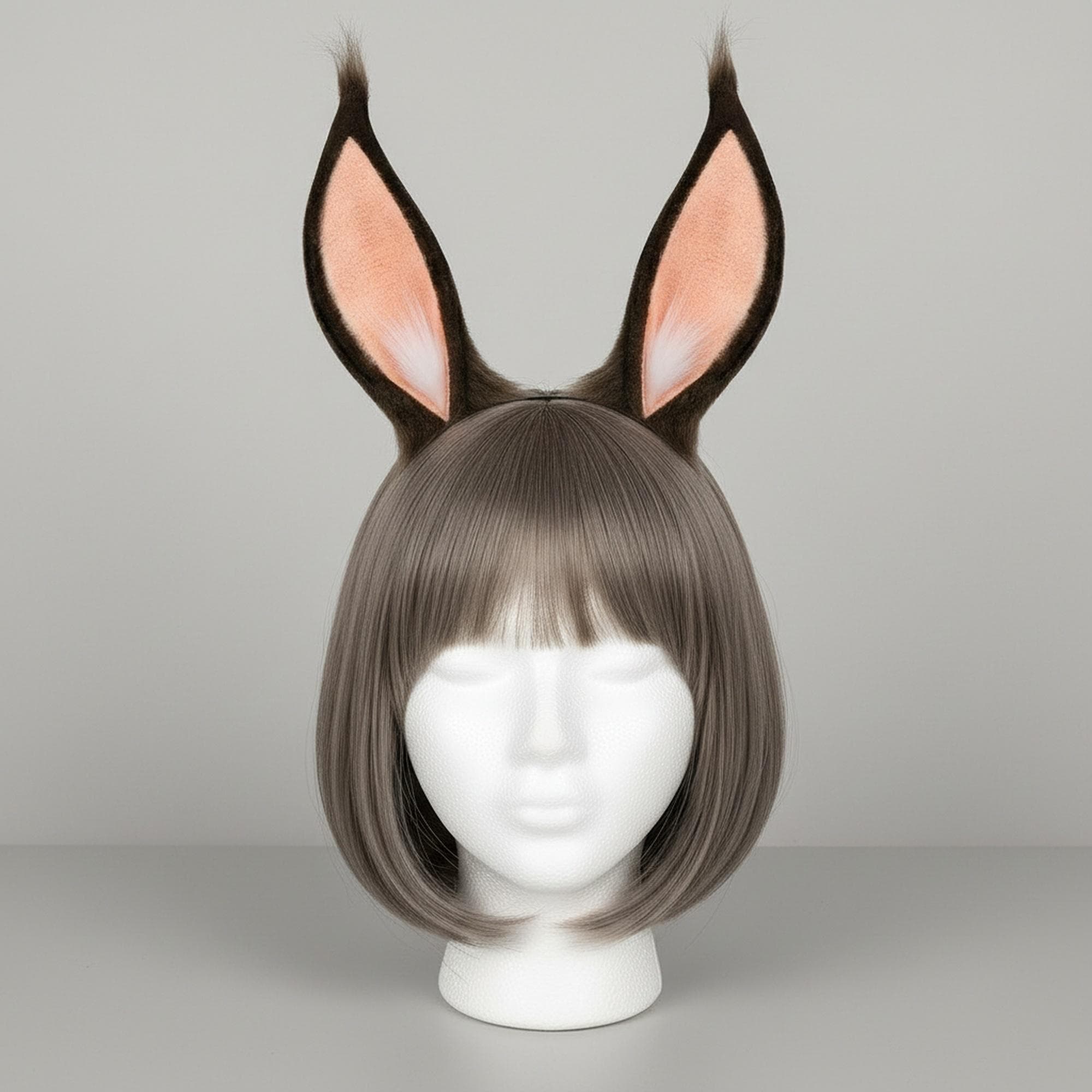 Anime-style rabbit ears headband in brown and pink displayed on a mannequin head with styled wig. Pointed faux fur bunny ears with dark brown outer and soft pink inner coloring featuring wispy decorative fur tufts at the ear tips and flowing fur fringes cascading from the base. Japanese anime inspired cosplay costume accessory mounted on a slim metal headband. Perfect for anime conventions, Halloween costumes, cosplay events, themed parties, photo shoots, and kawaii dress-up styling occasions